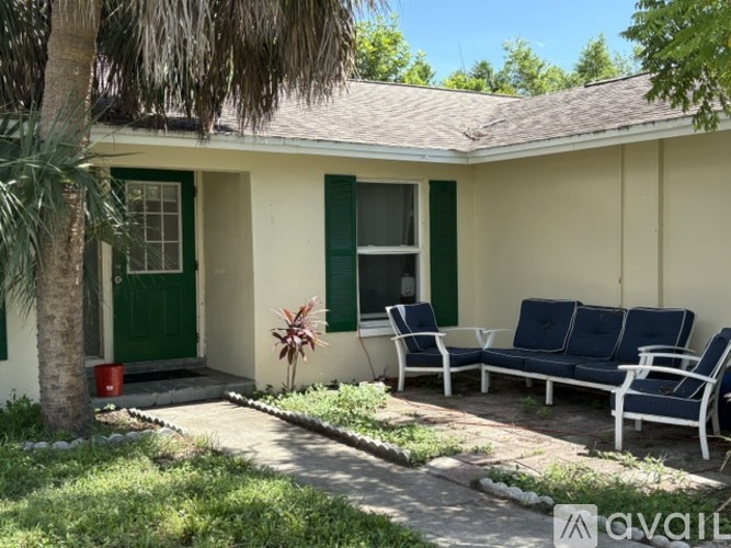 A house with a green door and a tree in front.