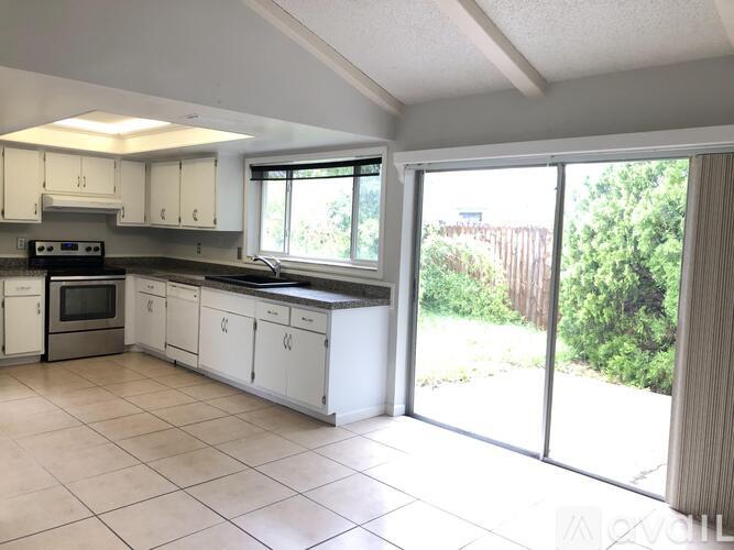A kitchen with white cabinets and a black stove top oven.