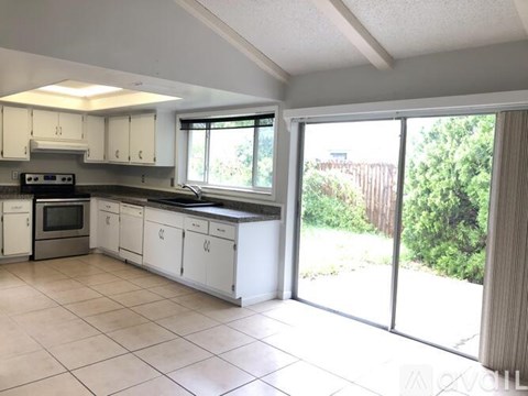 A kitchen with white cabinets and a black stove top oven.