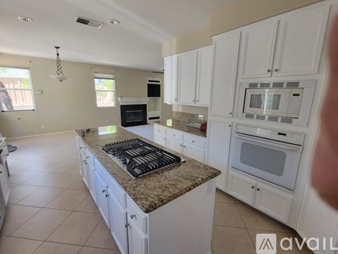 A kitchen with white cabinets and a granite countertop.