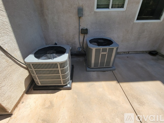 Two air conditioning units are outside a building.