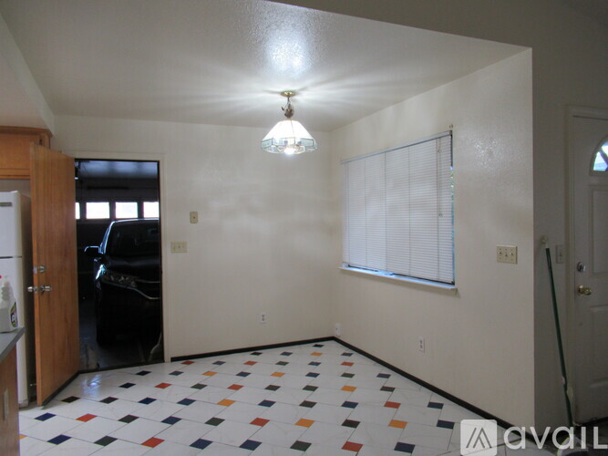 A room with a checkered floor and a window with blinds.