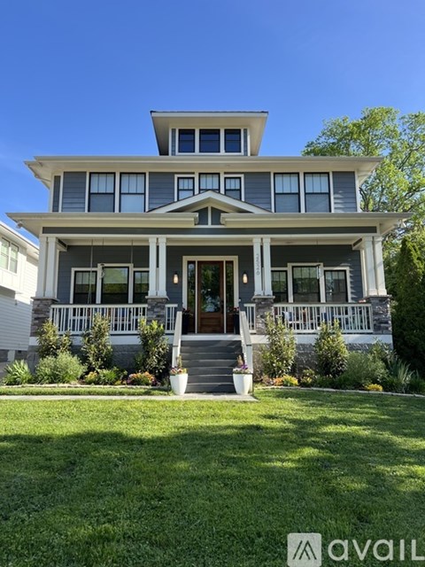 A two-story house with a front porch and a balcony.