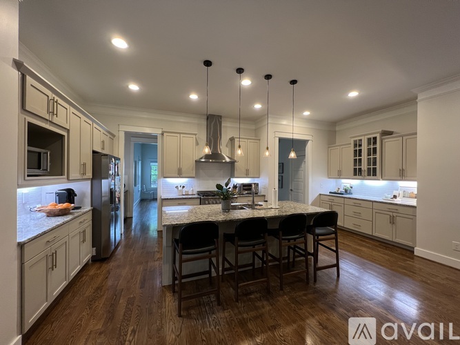 A modern kitchen with a center island and pendant lights.