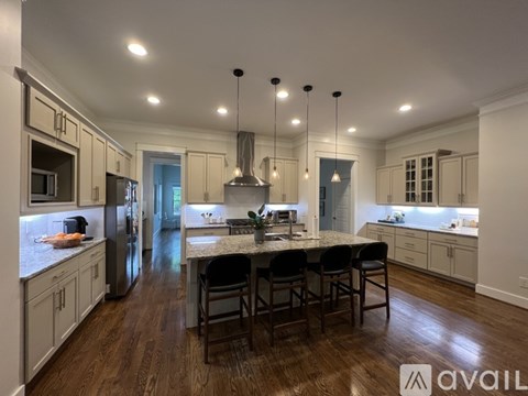 A modern kitchen with a center island and pendant lights.