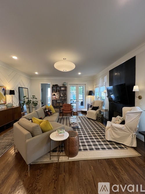 A living room with a grey sofa, a white armchair, and a coffee table.