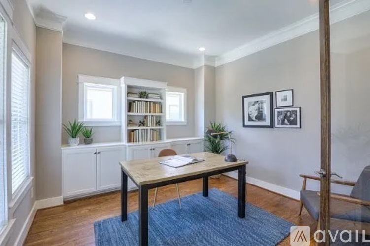 A room with a table, chairs, and a bookshelf.