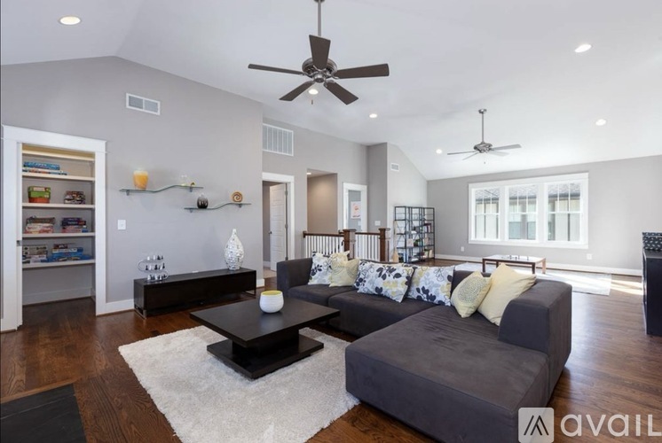 A living room with a grey couch and a black coffee table.