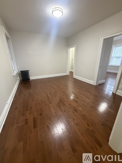 A room with wooden flooring and white walls.