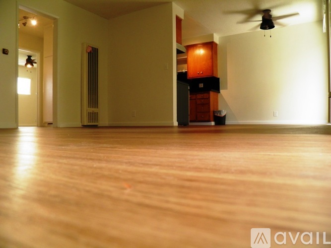 A room with wooden floors and a ceiling fan.