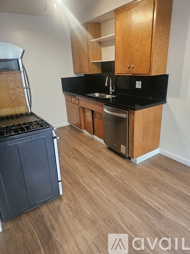 A kitchen with wooden cabinets and black countertops.
