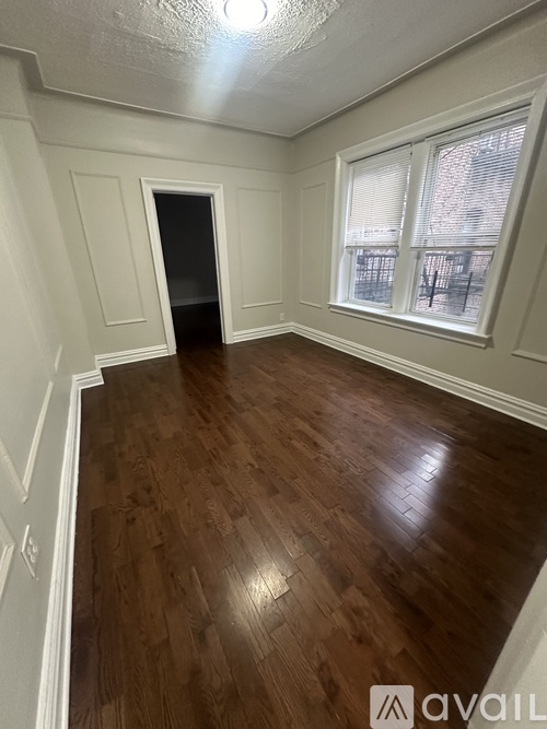 A room with wooden flooring and white walls.