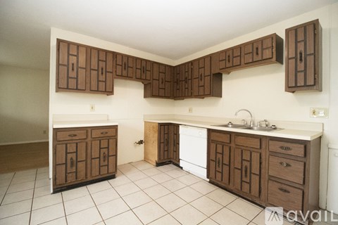 A kitchen with brown cabinets and white countertops.