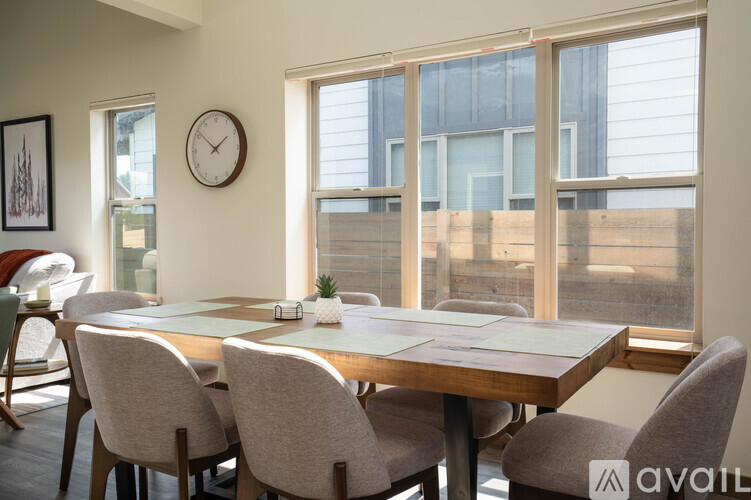 A dining room with a wooden table and chairs.