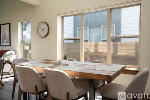 A dining room with a wooden table and chairs.