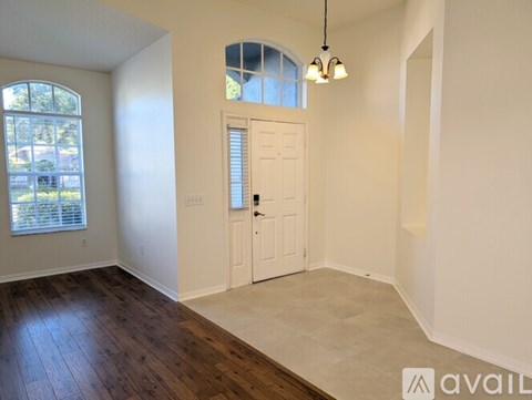 A room with a ceiling fan and sliding glass doors leading to a backyard.