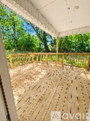 A wooden deck with a white ceiling and a wooden fence.
