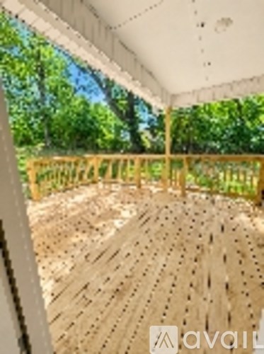 A wooden deck with a white ceiling and a wooden fence.