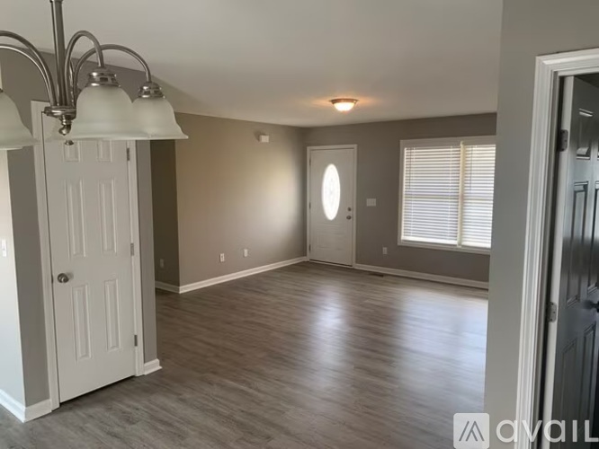 A room with a white door and a grey wall.