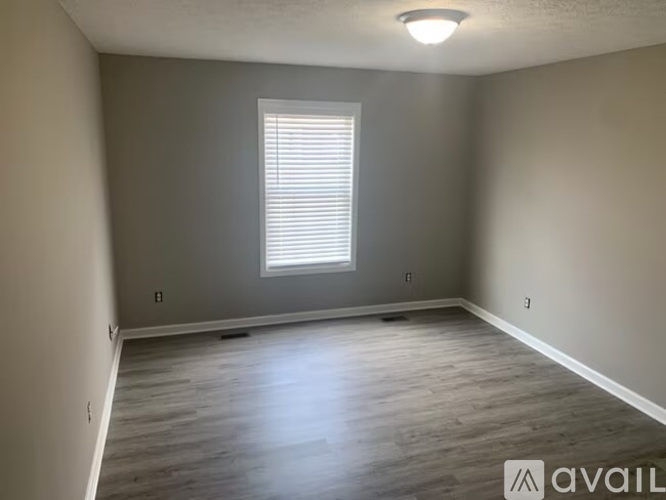 A room with a window and wooden flooring.