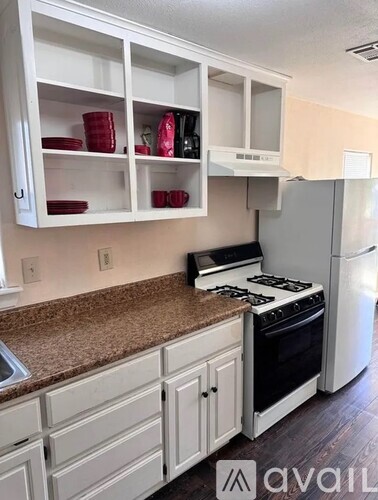 A kitchen with white cabinets and a granite countertop.