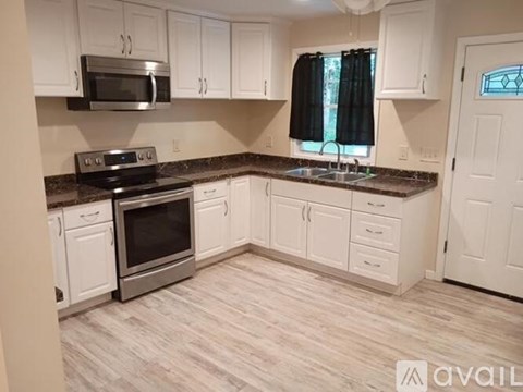 A kitchen with white cabinets and a black stove top oven.