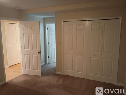 A room with two white doors and a carpeted floor.