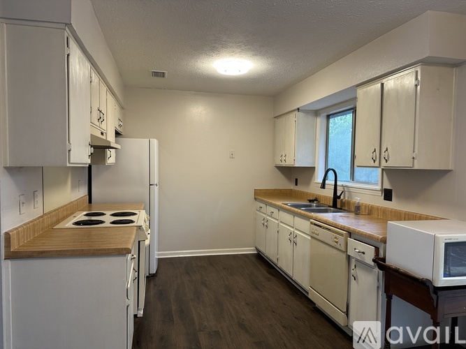 A kitchen with white appliances and cabinets.