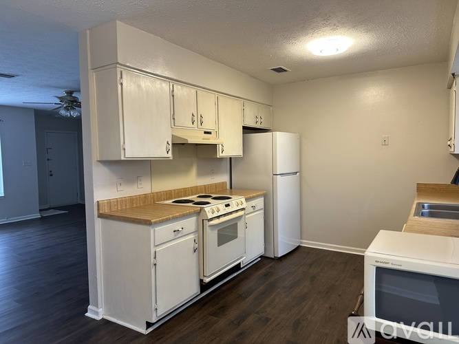 A kitchen with white appliances and cabinets.