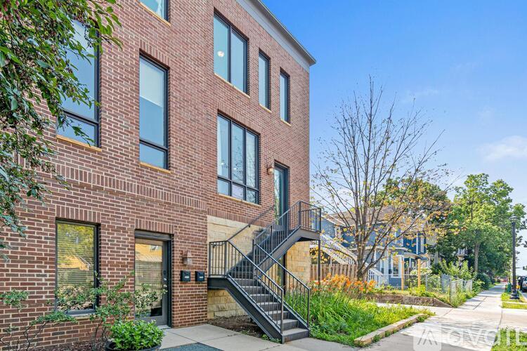 A red brick building with a black metal staircase.