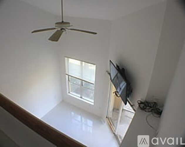 A room with a ceiling fan and a window.