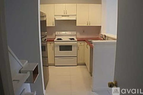 A kitchen with white cabinets and a stove top oven.