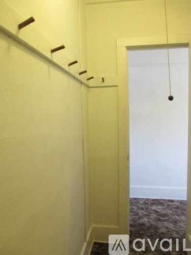 A hallway with a white door and a carpeted floor.