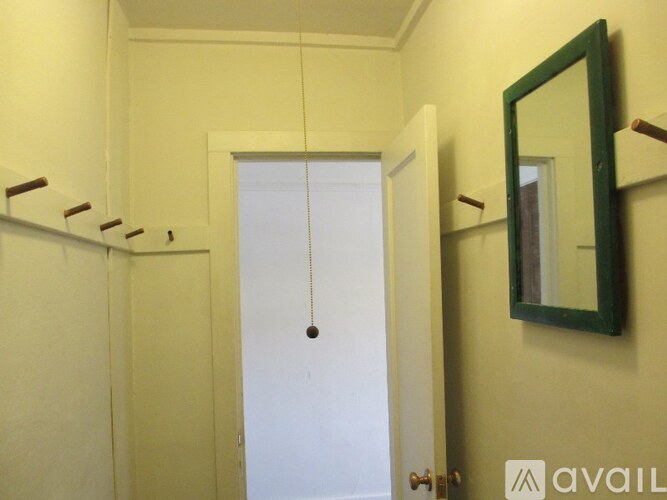 A bathroom with a white door and a mirror on the wall.