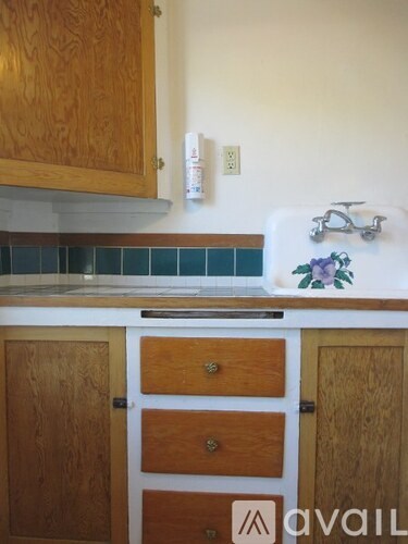A kitchen with wooden cabinets and a white fridge.