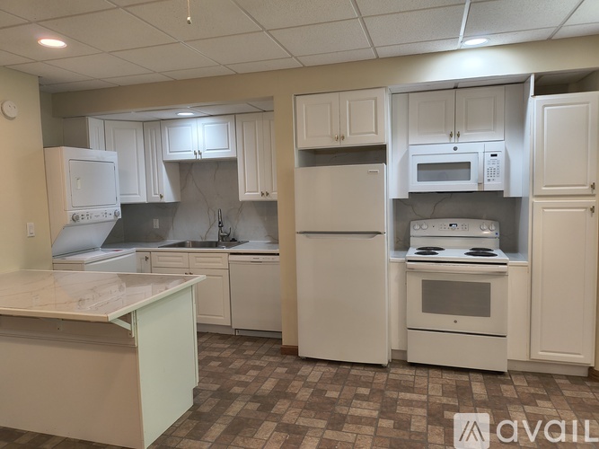 A kitchen with white appliances and cabinets.