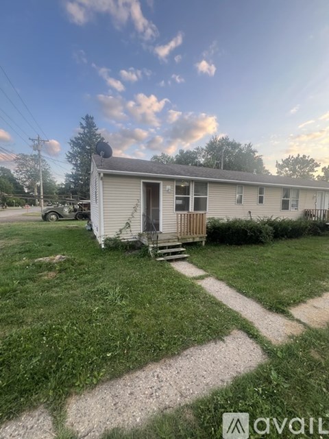 A small house with a porch and a yard.