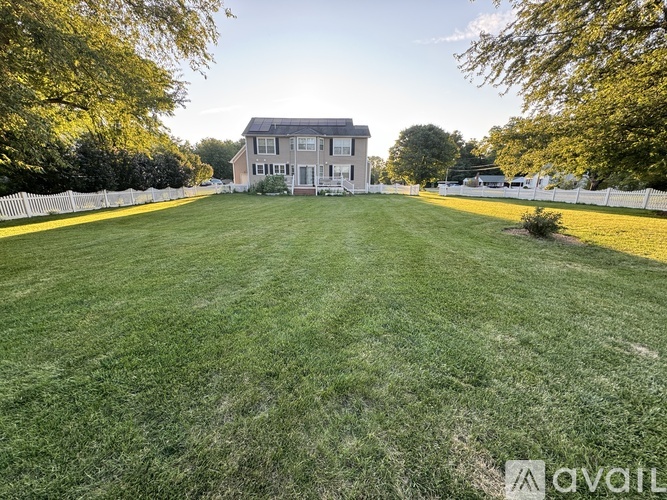 A large grassy field with a house in the background.