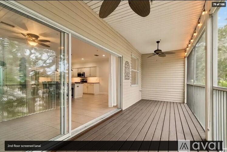 A wooden deck with sliding glass doors leading to a living room.