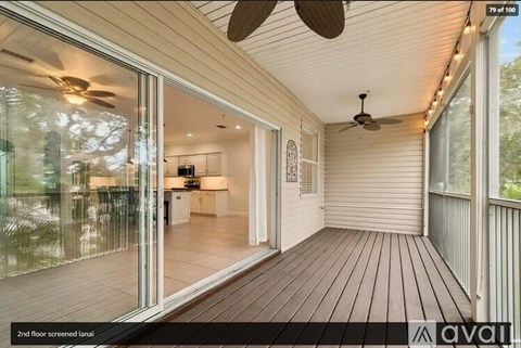 A wooden deck with sliding glass doors leading to a living room.