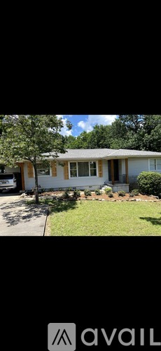 A house with a white fence and a tree in front.