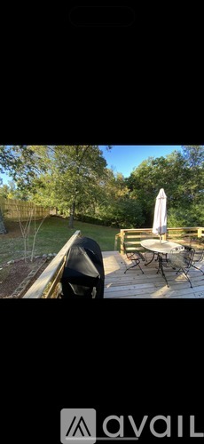A patio with a table and chairs and a white umbrella.