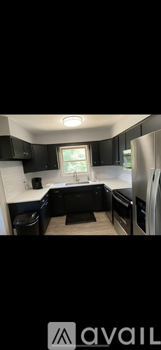 A kitchen with black cabinets and a window.