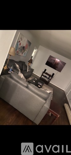 A grey couch with a black remote control on it.
