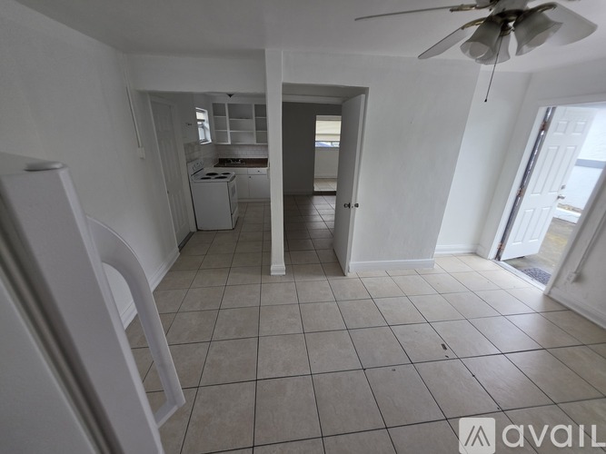 A spacious room with a ceiling fan and tiled flooring.