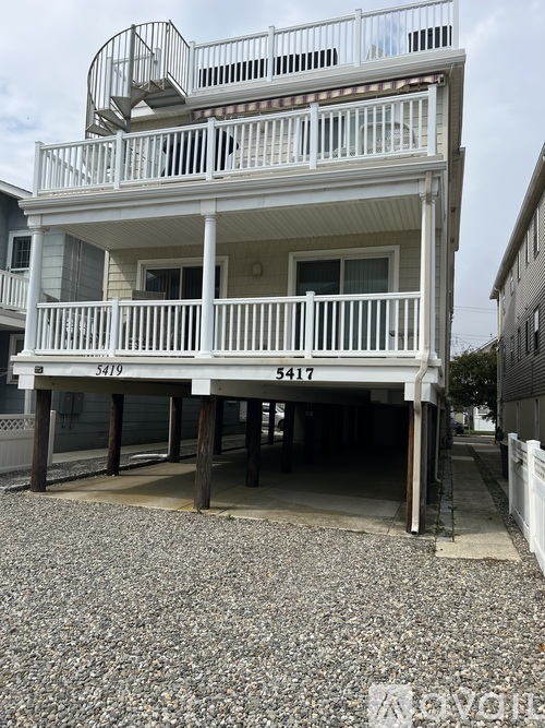 A two-story house with a balcony on the second floor.