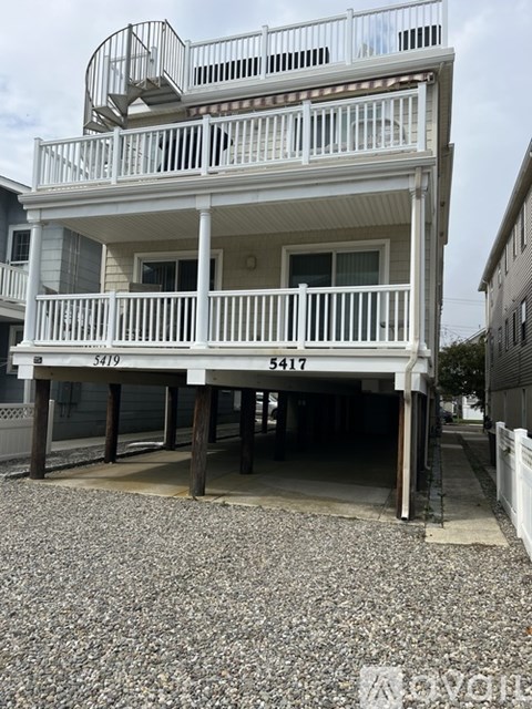 A two-story house with a balcony on the second floor.