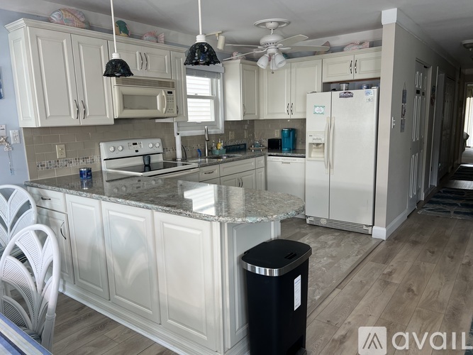 A kitchen with white cabinets and a granite countertop.