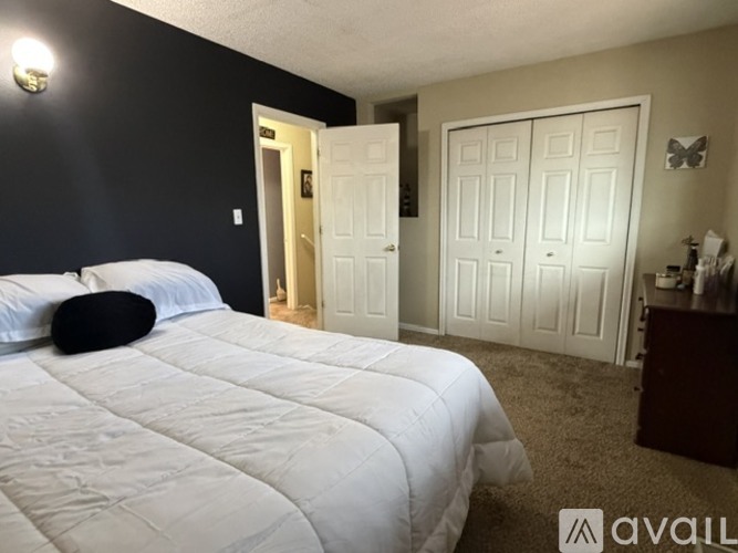 A bedroom with a large bed and a white door.
