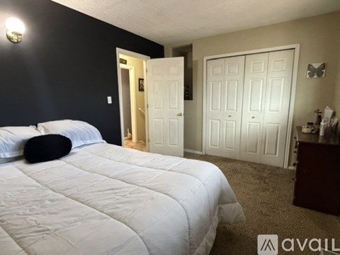 A bedroom with a large bed and a white door.